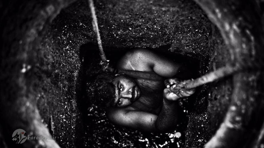 تصویری از یک کارگر تخلیه فاضلاب دهلی در چاه فاضلاب