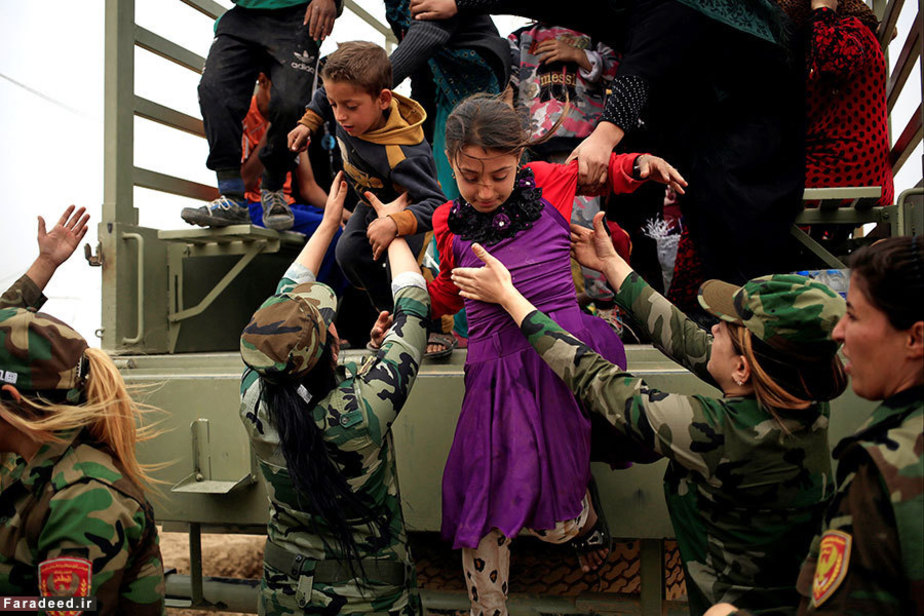 نیروهای پیشمرگه کرد در حال کمک به کودکان فراری از موصل