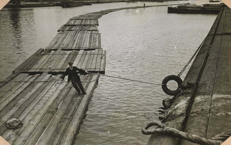 یک قایقران روی تنههای درختِ شناور روی آب مشغول. حدود سالهای 1930 تا 1945.