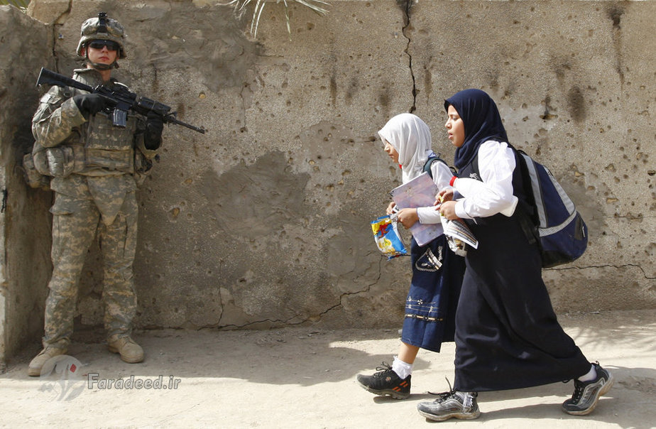 عراق (2008) دختران عراقی از کنار یک نیروی امنیتی در شهر بغداد عبور می کنند 