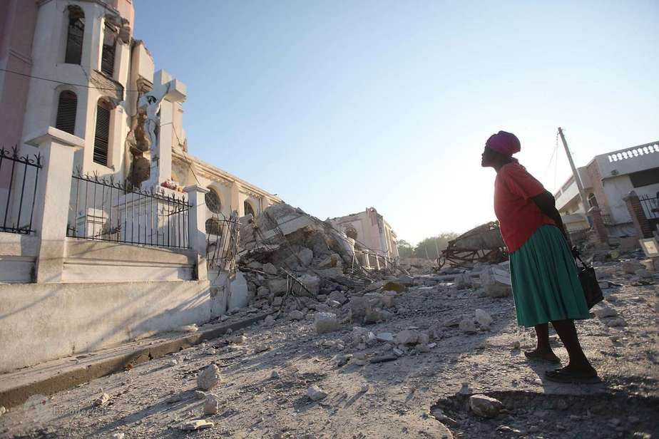  2010- زمین‌لرزه در هائیتی زنی در حال دعا در مقابل مجسمه مسیح در پورتوپرنس، هائیتی پس از زمین‌لرزه‌ای شدید و ویرانگر.