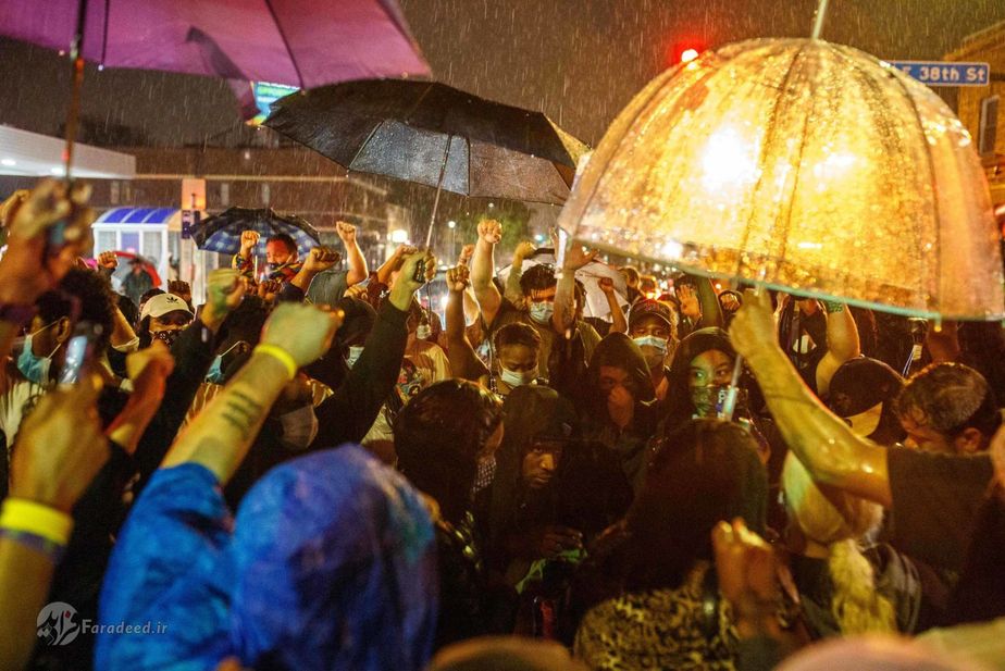 مردم زیر باران در محلی که جورج فلوید در آن جان سپرد. عکاس: Kerem Yucel/AFP/Getty Images